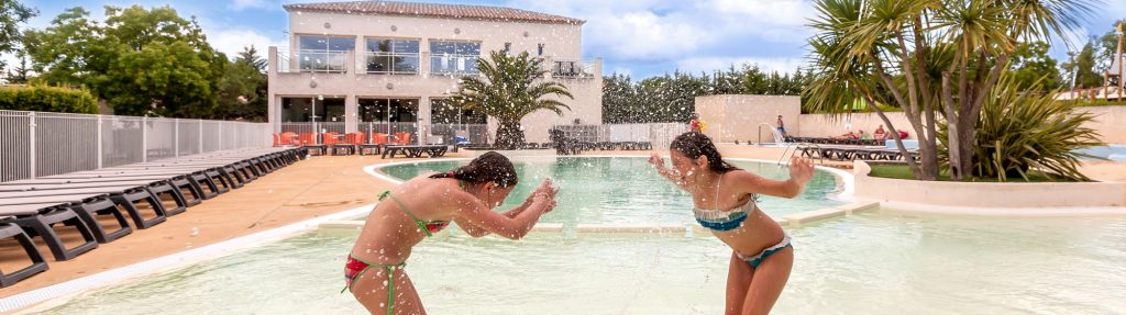 Enfants qui s'amusent dans la piscine du camping Les Amandiers dans le Gard